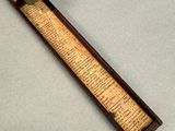 an old wooden ruler with a metal handle on a table