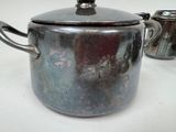 a silver pot sitting on a table next to a coffee pot