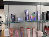 many different types of beauty products displayed on a glass shelf