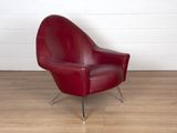 un fauteuil en cuir rouge posé sur un parquet en bois massif