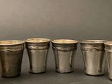 six silver cups are lined up in a row on a table