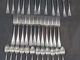 a lot of spoons and forks arranged together on a table