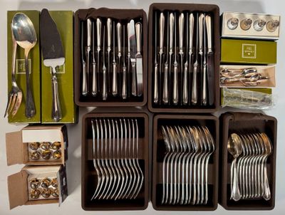 de nombreux types d'argenterie rangés dans des boîtes posées sur la table
