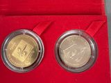 two different coins in a red box with a red velvet case