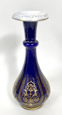 un vase bleu orné d'un motif doré