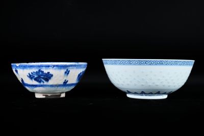 deux bols bleus et blancs ornés de motifs, posés sur un fond noir