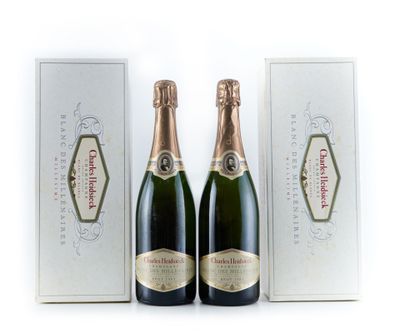 deux bouteilles de champagne devant une boîte blanche