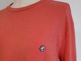 a close up of a red sweatshirt with a small badge on it