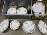 plusieurs assiettes et bols dans une boîte posée sur le sol
