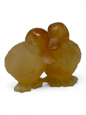 a small figurine of two birds on a white background