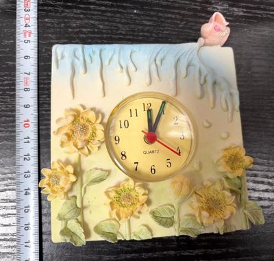 a clock that is sitting on a table next to a ruler