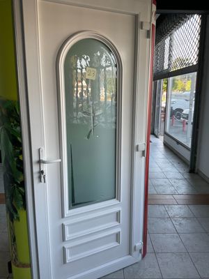 une porte blanche avec une vitre au milieu d'une pièce