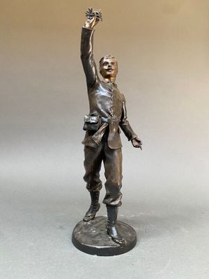 statue en bronze représentant un homme tenant un oiseau dans la main
