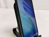a phone that is sitting on a stand on a bed