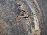 a rusted tire with a bolt in the center
