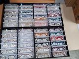 a drawer full of glasses on a desk next to a computer