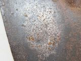 a rusted piece of metal on the floor of a bathroom