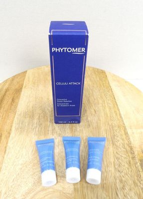 three tubes of phytomer sitting on a wooden table next to a blue box