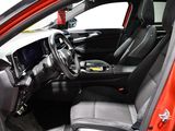 the interior of a red car with black seats and a steering wheel