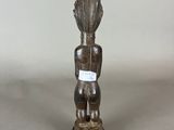a wooden statue of a man with a shell on his head