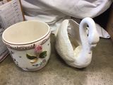a white swan shaped cup next to a white swan shaped cup