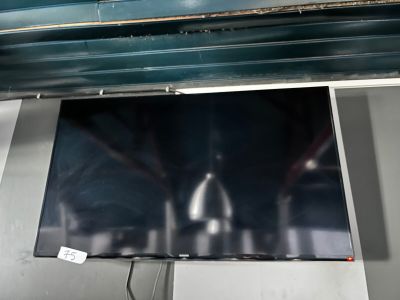 un téléviseur à écran plat suspendu au plafond dans une pièce