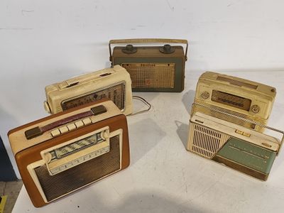 Plusieurs radios à l'ancienne sont posées sur une table