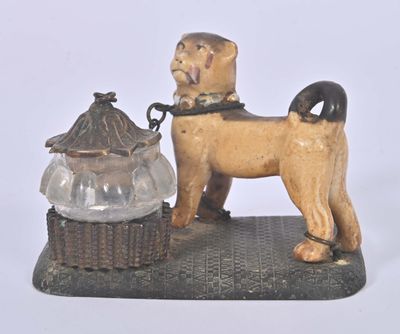a statue of a dog with a bowl on a table