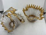 pair of gold and white glass vases sitting on top of a white surface