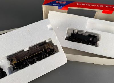two model trains sitting in a box on a table