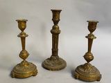 trois bougeoirs anciens en laiton sur fond blanc