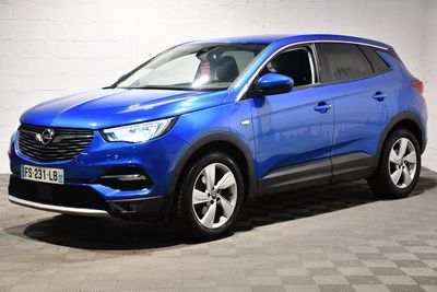La voiture bleue est garée dans un garage dont le sol est à carreaux.