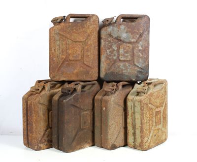 several old rusty metal jerry cans stacked on top of each other