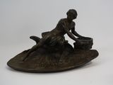 bronze figurine of a woman sitting on a boat with a dog