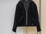 une veste noire suspendue à un portant dans une pièce