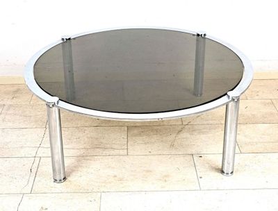 une table en noir et blanc avec un plateau en verre, posée sur un sol carrelé