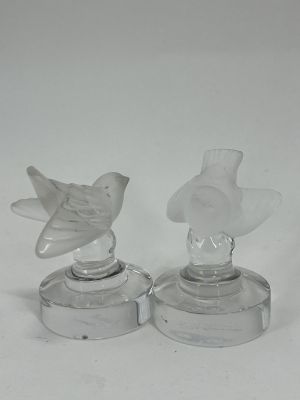 pair of clear glass bird figurines sitting on top of each other