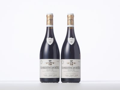 two bottles of wine sitting on top of a white table