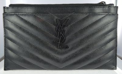a close up of a black purse on a white table