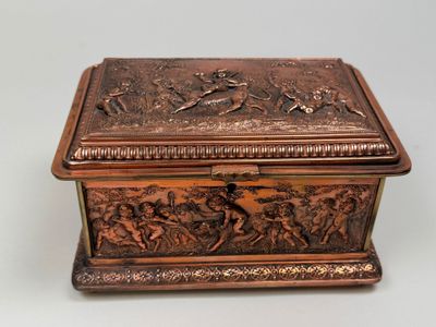 an antique bronze box with a scene on it on a table