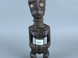 figurine en bois représentant un homme avec une pancarte sur la poitrine