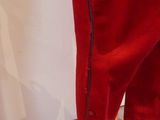 a pair of red pants that are on a wooden stand