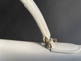 a close up of a white purse on a table