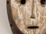 un vieux masque en bois percé de trous au milieu du visage