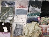 de nombreux vêtements de toutes sortes dans le sac posé sur le lit