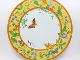 assiette jaune et orange ornée d'un papillon et de fleurs