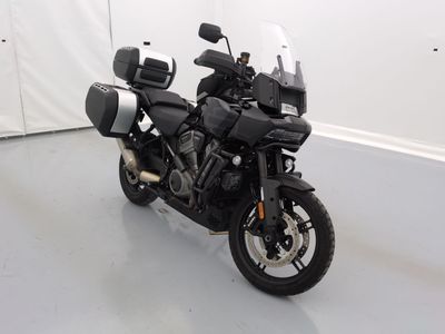 une moto noire garée dans une pièce aux murs blancs