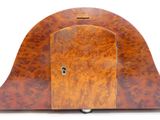 une horloge en bois avec une clé à l'intérieur, posée sur une surface blanche