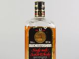 une photo d'une bouteille de whisky posée sur une surface blanche