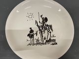a black and white plate with a drawing of a man on a horse